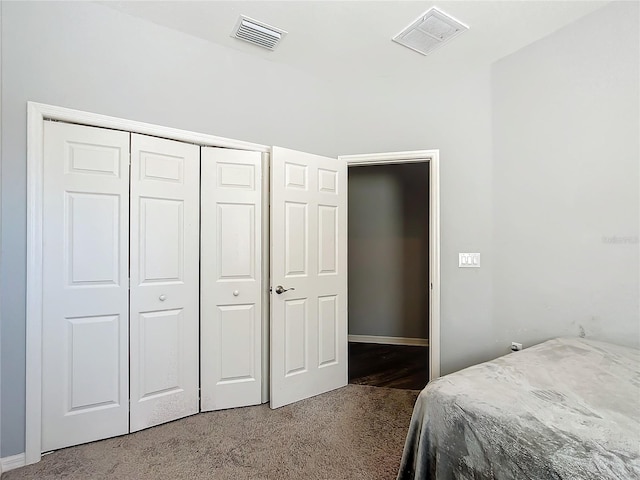 carpeted bedroom featuring a closet and visible vents