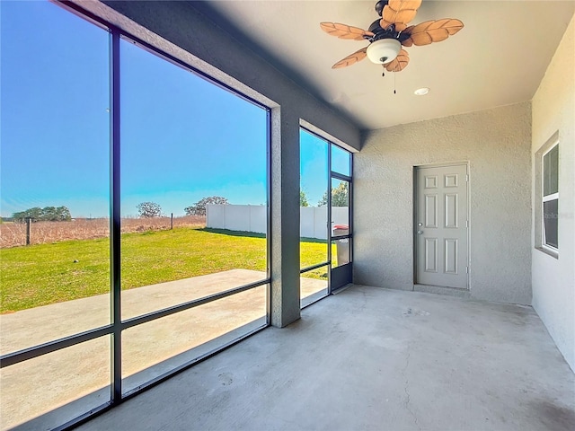 unfurnished sunroom with a ceiling fan