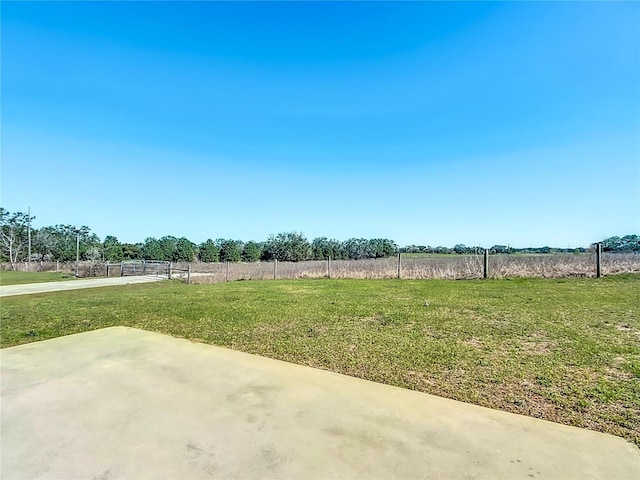 view of yard with a rural view and fence