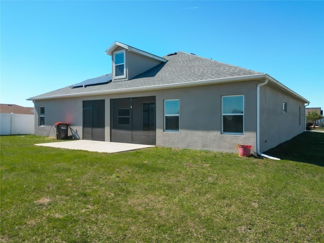 rear view of property with a patio area, a yard, fence, and stucco siding