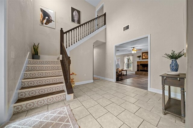 4161 NE 185th Ave, Williston, FL 32696 - interior space featuring ceiling fan, a towering ceiling, a tiled fireplace, and tile patterned flooring