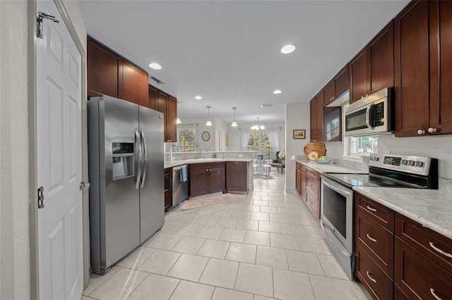 4161 NE 185th Ave, Williston, FL 32696 - kitchen with pendant lighting, sink, light tile patterned floors, appliances with stainless steel finishes, and kitchen peninsula