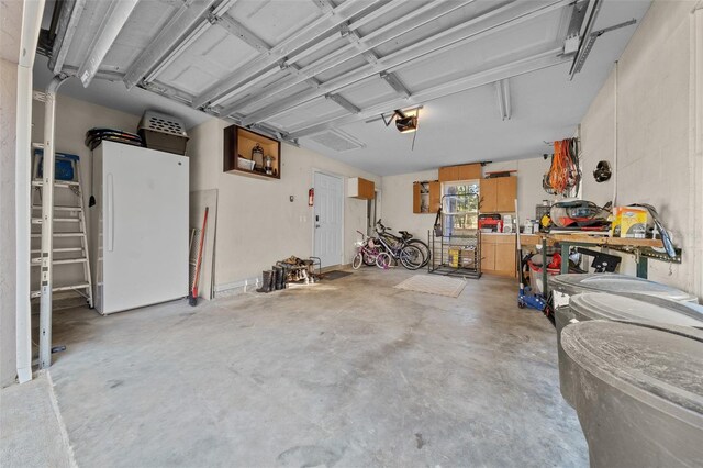 4161 NE 185th Ave, Williston, FL 32696 - garage with a garage door opener, a workshop area, and white refrigerator