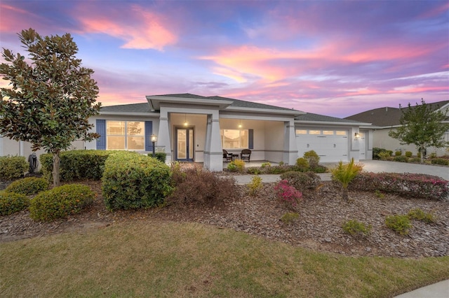 view of front of home with driveway, a front yard, an attached garage, and stucco siding