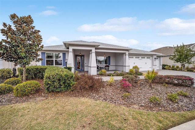 view of front of property featuring concrete driveway, a front yard, an attached garage, and stucco siding