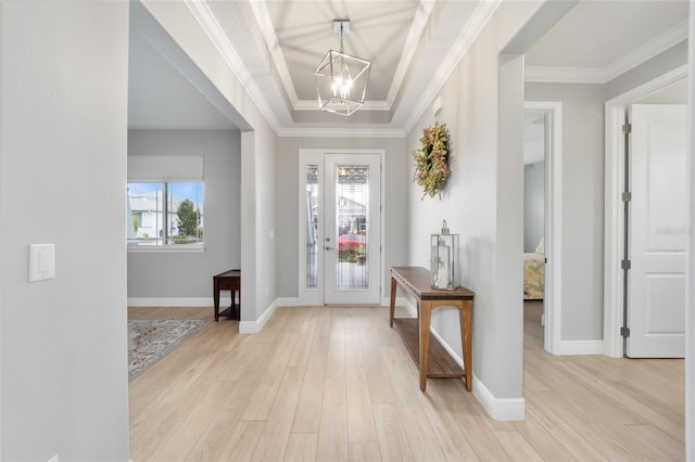 entryway with a notable chandelier, light wood-type flooring, baseboards, and crown molding