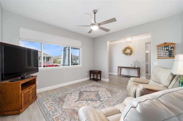 living room featuring light wood-type flooring, ceiling fan, and baseboards