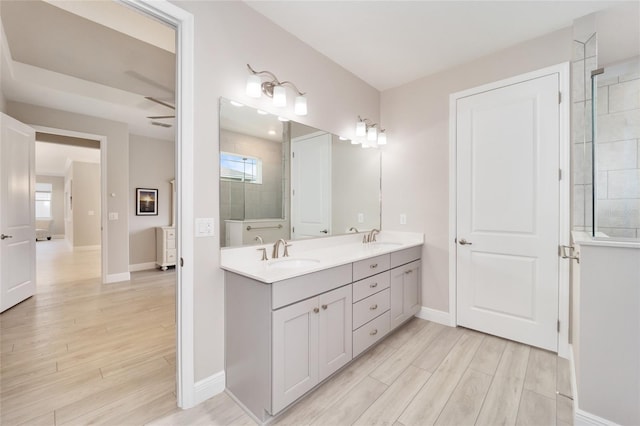 bathroom featuring double vanity, a sink, and wood finished floors