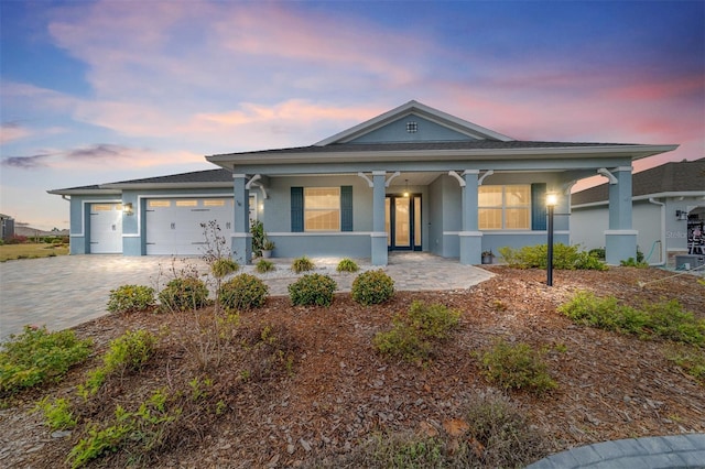 view of front of home with a garage, decorative driveway, and stucco siding