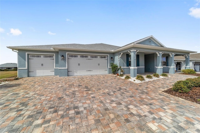 view of front of property with a garage, decorative driveway, and stucco siding