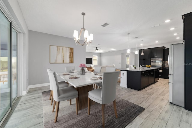 dining room with baseboards, light wood-style flooring, visible vents, and a healthy amount of sunlight