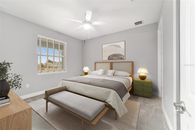 bedroom with light carpet, a ceiling fan, visible vents, and baseboards