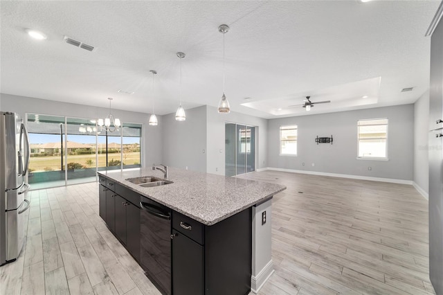 kitchen featuring black dishwasher, open floor plan, a sink, an island with sink, and stainless steel fridge with ice dispenser