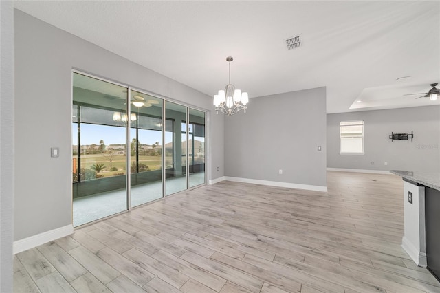 unfurnished room with light wood-type flooring, visible vents, baseboards, and ceiling fan with notable chandelier