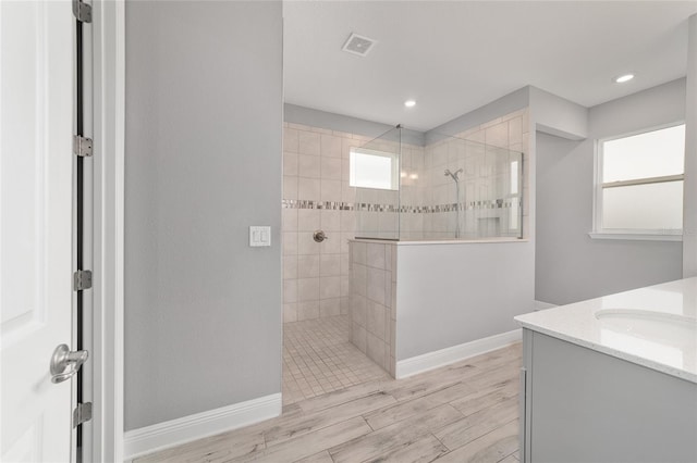 full bathroom with wood finished floors, visible vents, vanity, and a walk in shower