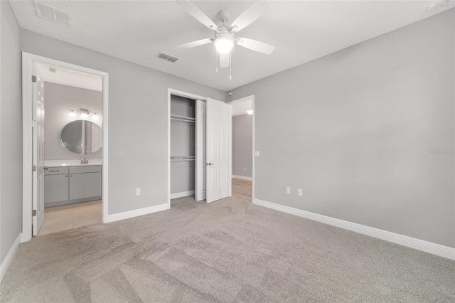 unfurnished bedroom featuring baseboards, a closet, visible vents, and light colored carpet