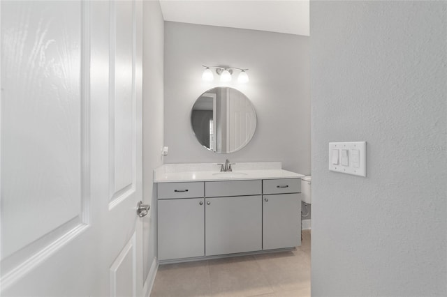 half bath with vanity, toilet, and tile patterned floors