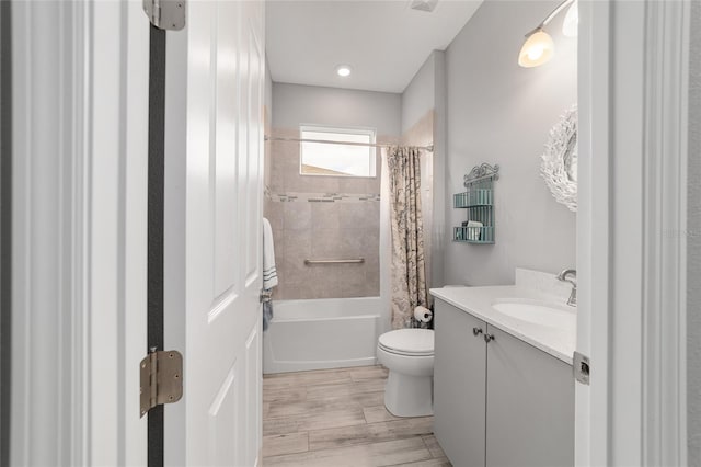 bathroom featuring toilet, shower / tub combo, wood finished floors, and vanity