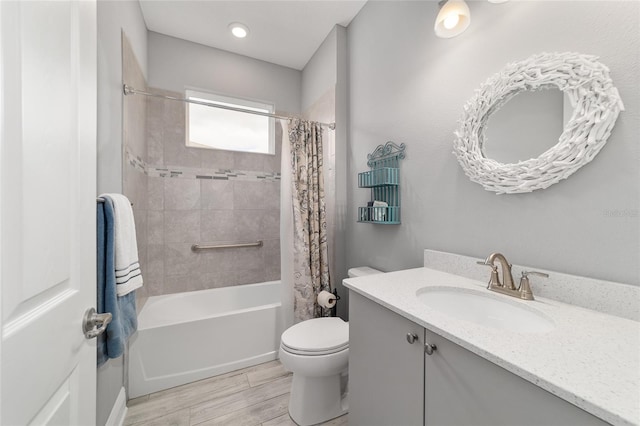 full bath with wood tiled floor, vanity, toilet, and shower / bath combo with shower curtain