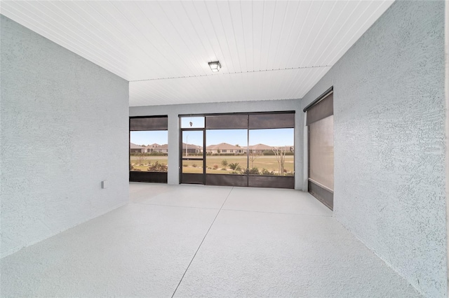 empty room featuring light speckled floor and a textured wall