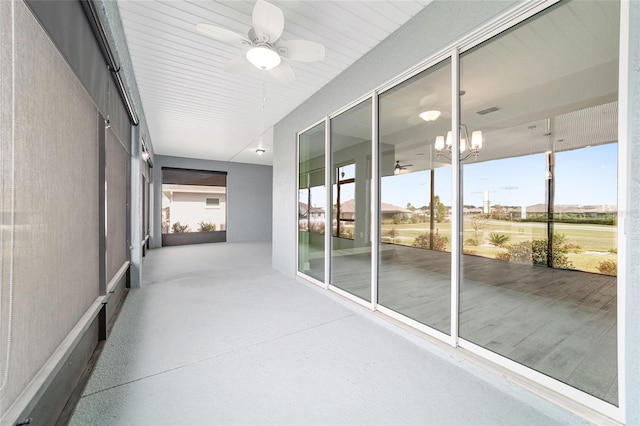 unfurnished sunroom with ceiling fan with notable chandelier