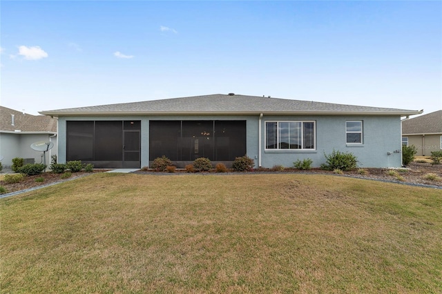 rear view of property with a sunroom, a lawn, and stucco siding