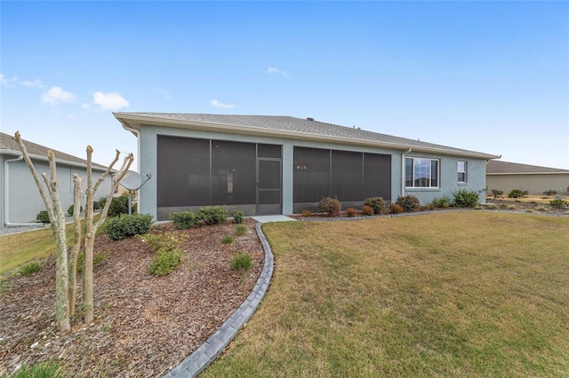 rear view of property featuring a sunroom and a lawn