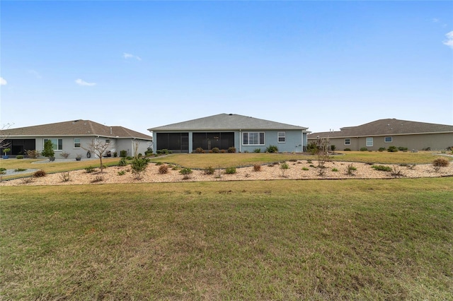 view of front of property featuring a front yard and a sunroom