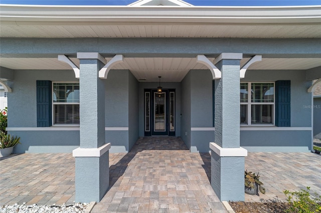 8107 SW 92nd Cir, Ocala, FL 34481 - doorway to property with stucco siding and covered porch