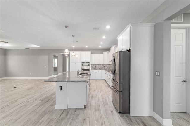 8107 SW 92nd Cir, Ocala, FL 34481 - kitchen featuring appliances with stainless steel finishes, a sink, light wood finished floors, baseboards, and dark stone counters