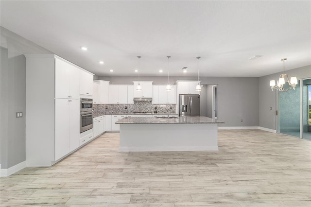 8107 SW 92nd Cir, Ocala, FL 34481 - kitchen with appliances with stainless steel finishes, decorative backsplash, light wood finished floors, a kitchen island with sink, and recessed lighting