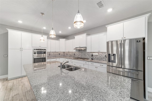 8107 SW 92nd Cir, Ocala, FL 34481 - kitchen with appliances with stainless steel finishes, a sink, a kitchen island with sink, white cabinetry, and decorative backsplash
