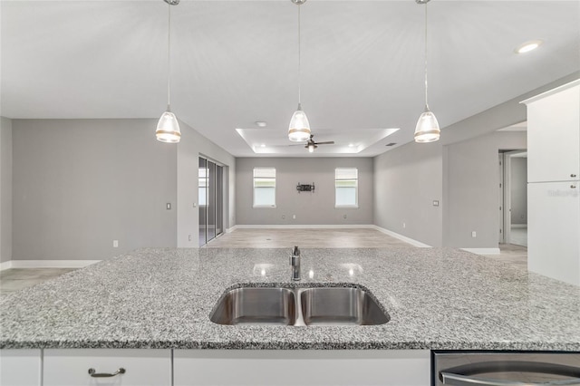 8107 SW 92nd Cir, Ocala, FL 34481 - kitchen with a sink, open floor plan, a tray ceiling, and light stone counters