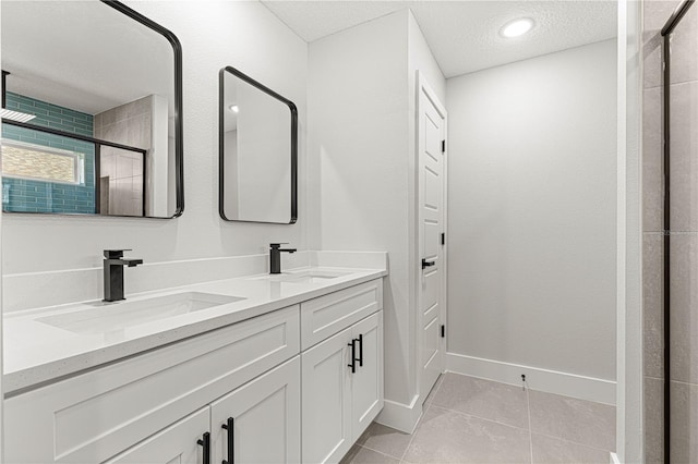 bathroom with a textured ceiling, a shower with door, tile patterned flooring, and vanity