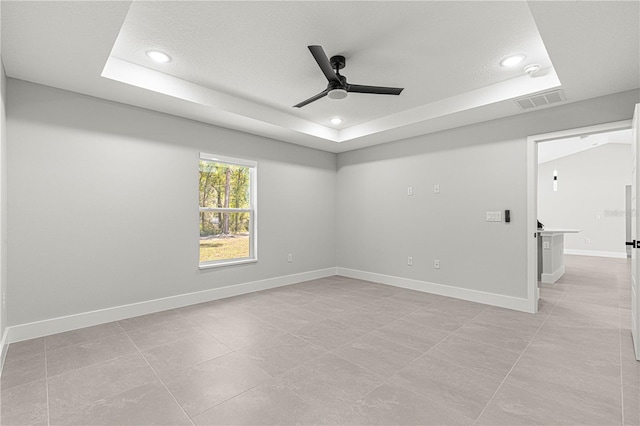 spare room featuring ceiling fan and a tray ceiling