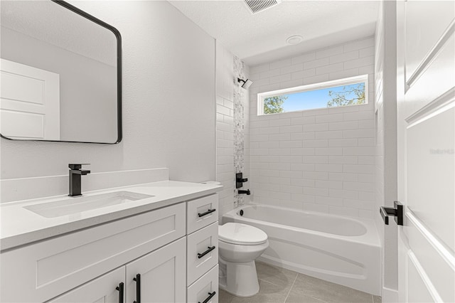 full bathroom with vanity, a textured ceiling, tiled shower / bath, tile patterned flooring, and toilet