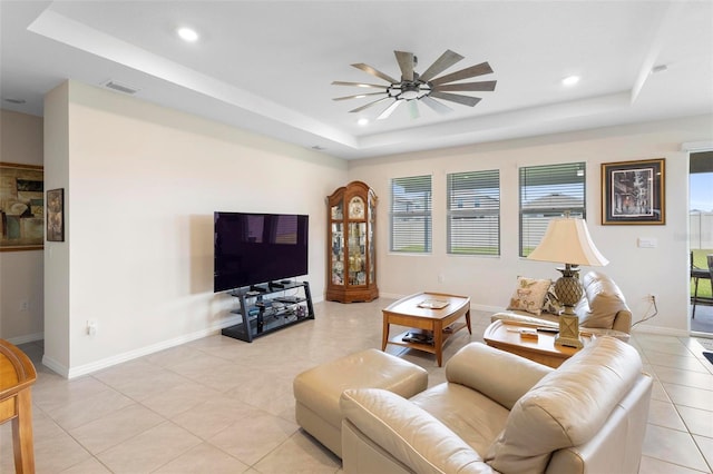 living room with baseboards, a raised ceiling, a ceiling fan, and recessed lighting