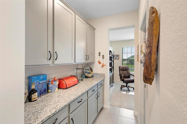 kitchen featuring light stone counters, gray cabinets, and light tile patterned flooring