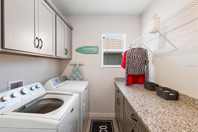 laundry room with cabinet space, baseboards, and washing machine and clothes dryer