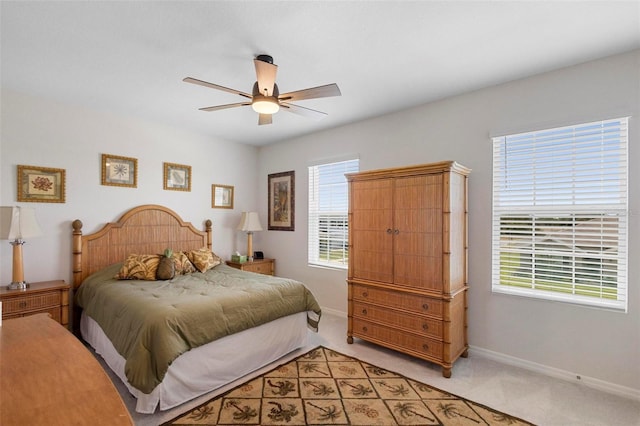 bedroom with light carpet, ceiling fan, and baseboards