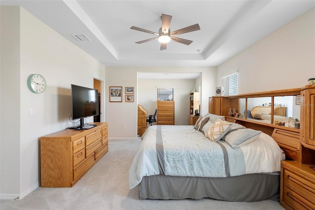 bedroom featuring baseboards, a tray ceiling, visible vents, and light colored carpet