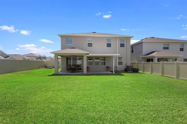 rear view of property with central air condition unit, a patio area, a lawn, and stucco siding