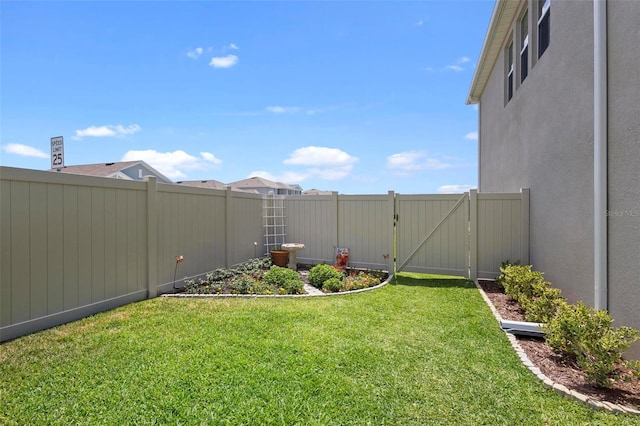 view of yard with a gate and a fenced backyard