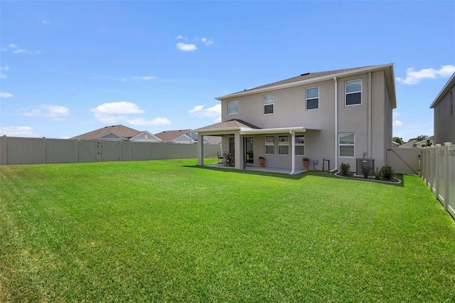 rear view of property with stucco siding, a lawn, a patio area, cooling unit, and a fenced backyard