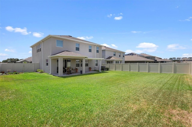 back of property with a patio area, a fenced backyard, a lawn, and stucco siding