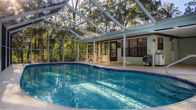 pool with glass enclosure and a patio