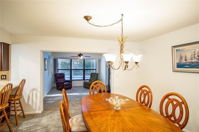 dining space with carpet, baseboards, and a notable chandelier