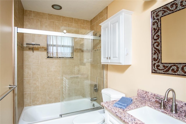 full bath with combined bath / shower with glass door, vanity, and toilet