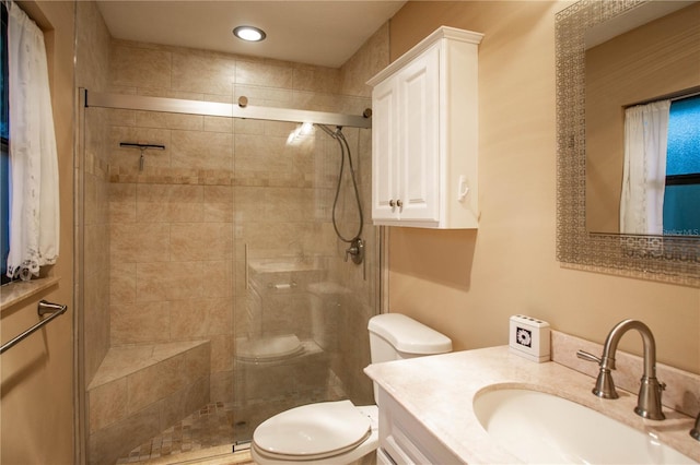 bathroom featuring a stall shower, vanity, and toilet