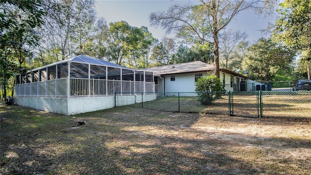 back of house with a sunroom, a gate, and fence